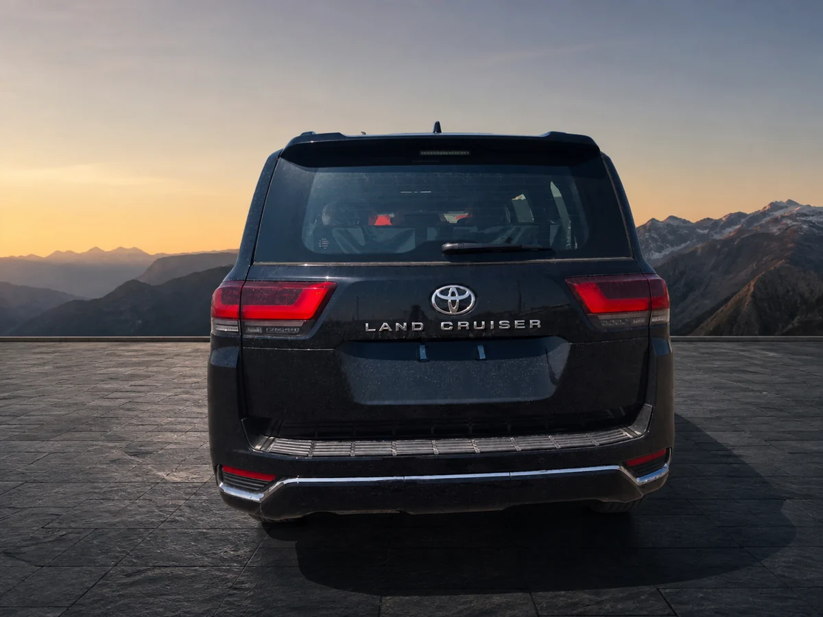 Rear exterior of the dark 2026 Land Cruiser 300 ZX LHD in a premium mountain environment