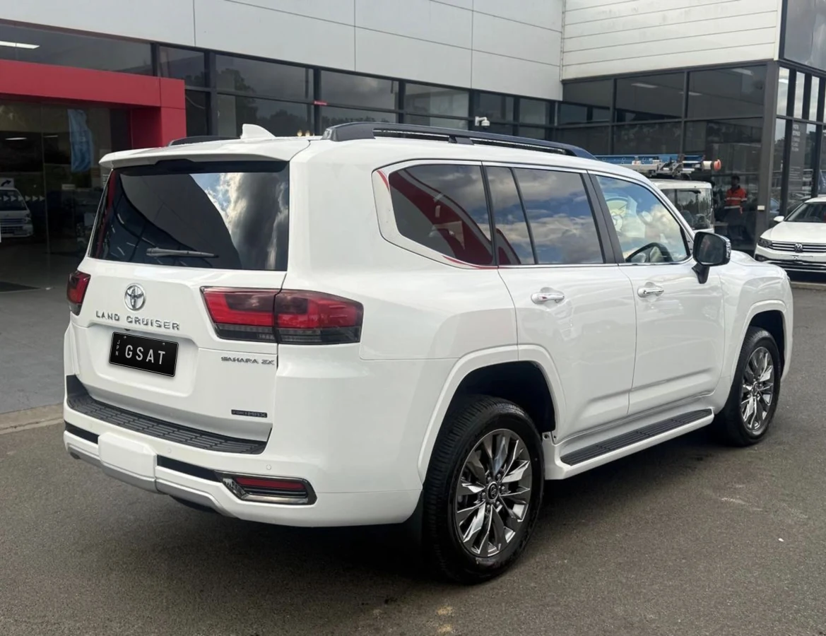 Rear three-quarter exterior of the white LC300 Sahara ZX hybrid