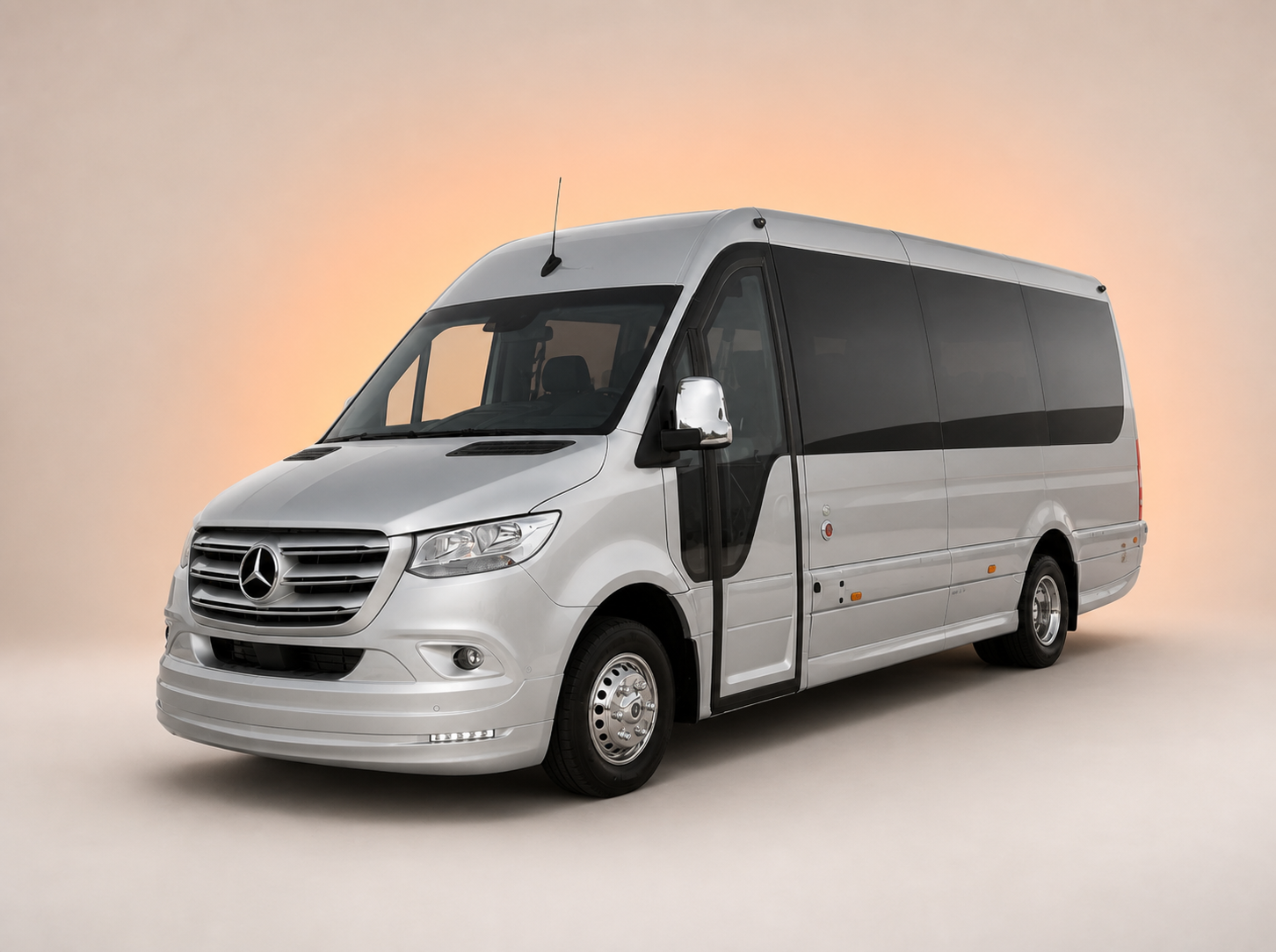 Silver Mercedes-Benz Sprinter EVM Avantgarde 16-seater minibus on an orange studio background